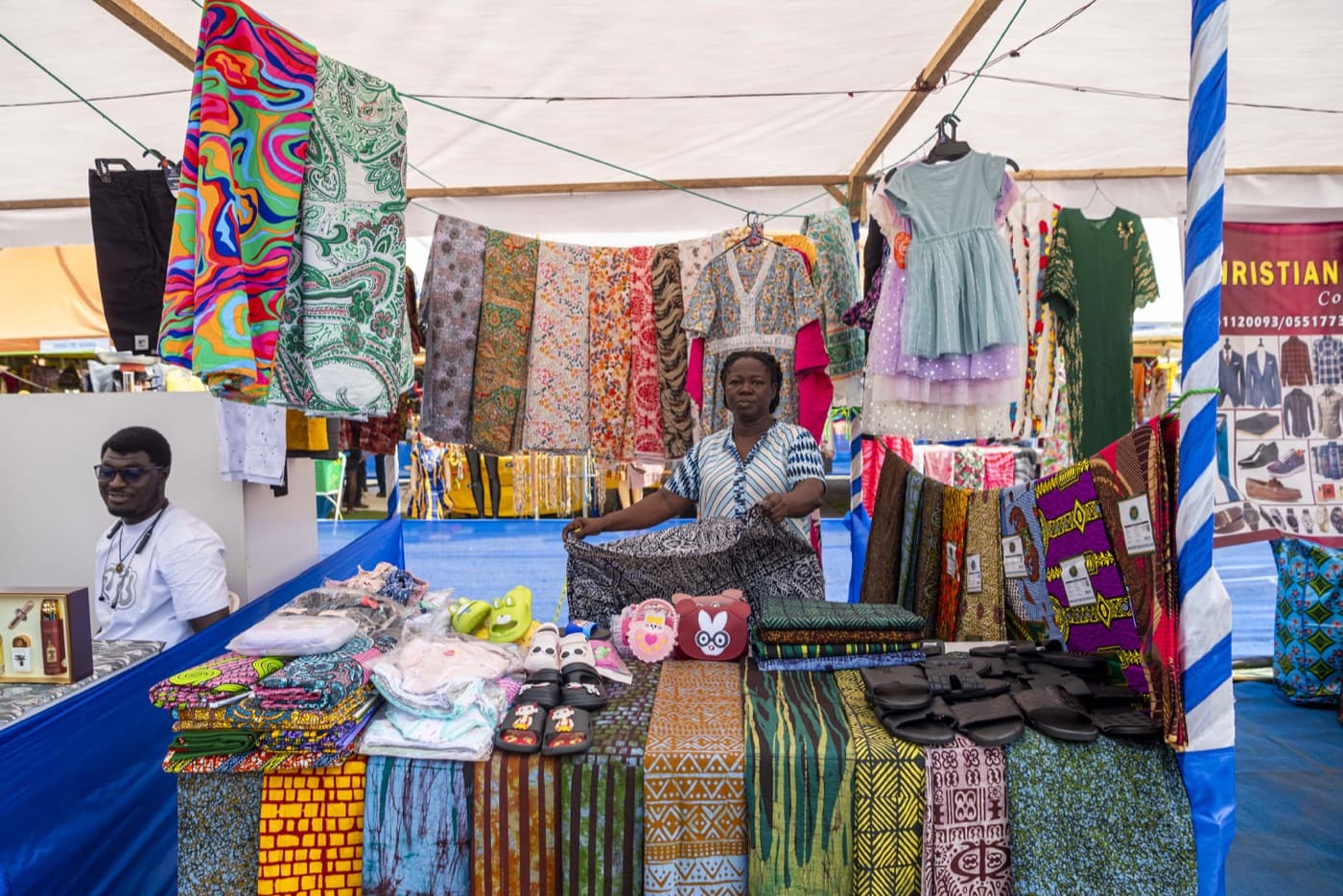 Fabrics and fashion accessories stacked high at a clothing stall